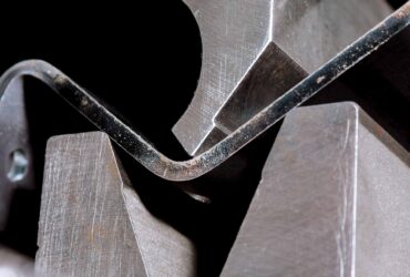 The process of bending sheet metal on a hydraulic bending machine. Metalworking plant.