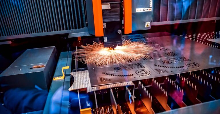 CNC Laser cutting of metal, modern industrial technology. Small depth of field. Warning - authentic shooting in challenging conditions.